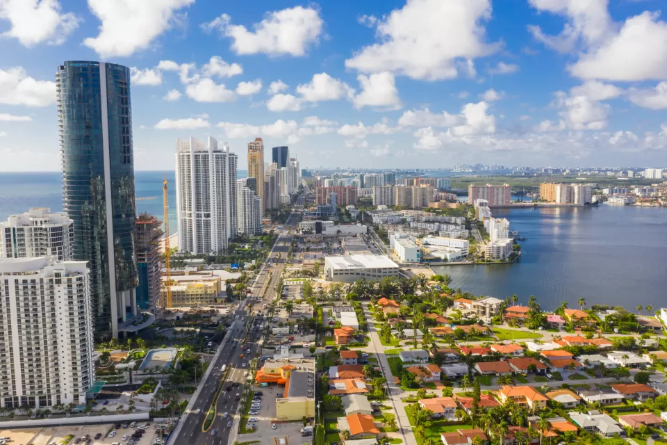 Aerial view of Miami, Florida with high-rises along beach and low-rise homes inlower right corner